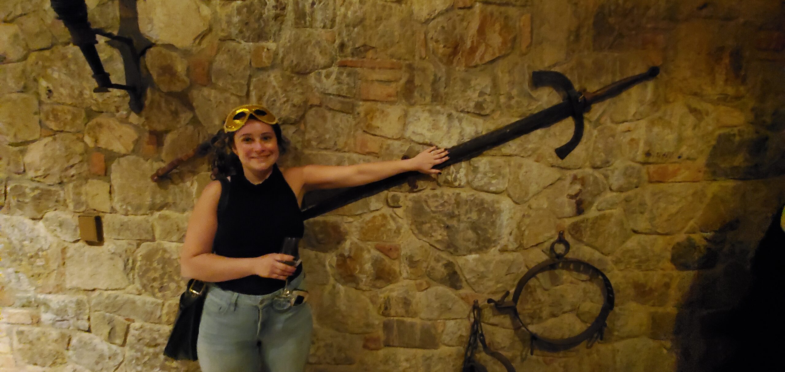Ava with a longsword in the weapons room of Castello di Amorosa.
